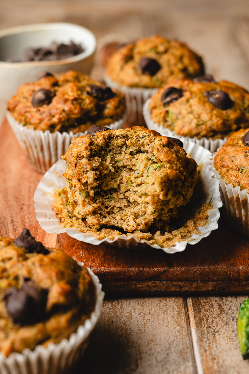 vegan chocolate chip zucchini muffin with a bite taken out of it