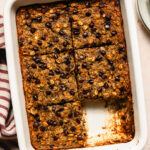 baking dish of chocolate chip zucchini baked oatmeal with a slice missing