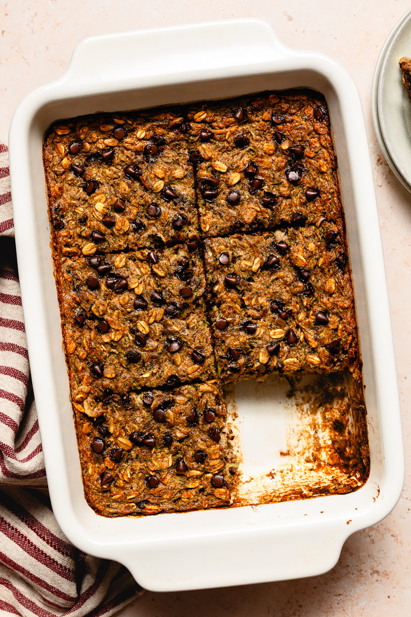 baking dish of chocolate chip zucchini baked oatmeal with a slice missing